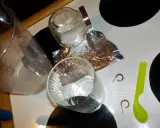 Przygotowania do czyszczenia złota folią aluminiową: szklanka, słoik, folia, łyżeczka i kolczyki.