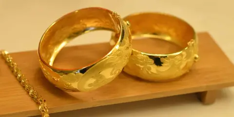 Dwa złote, bogato zdobione bransolety i łańcuszek. Jak odróżnić złoto od pozłacanego?