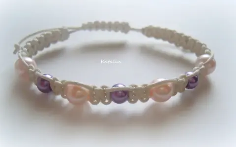 Bransoletka shamballa z perłami w kolorach pudrowego różu i fioletu, wykonana techniką makramy.