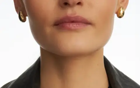 Złote kolczyki w kształcie kropli, które nie uczulają, dodają elegancji.