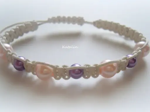 Bransoletka shamballa z perłami w kolorach pudrowego różu i fioletu, wykonana techniką makramy.