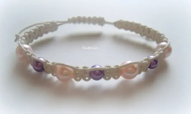 Bransoletka shamballa z perłami w kolorach pudrowego różu i fioletu, wykonana techniką makramy.