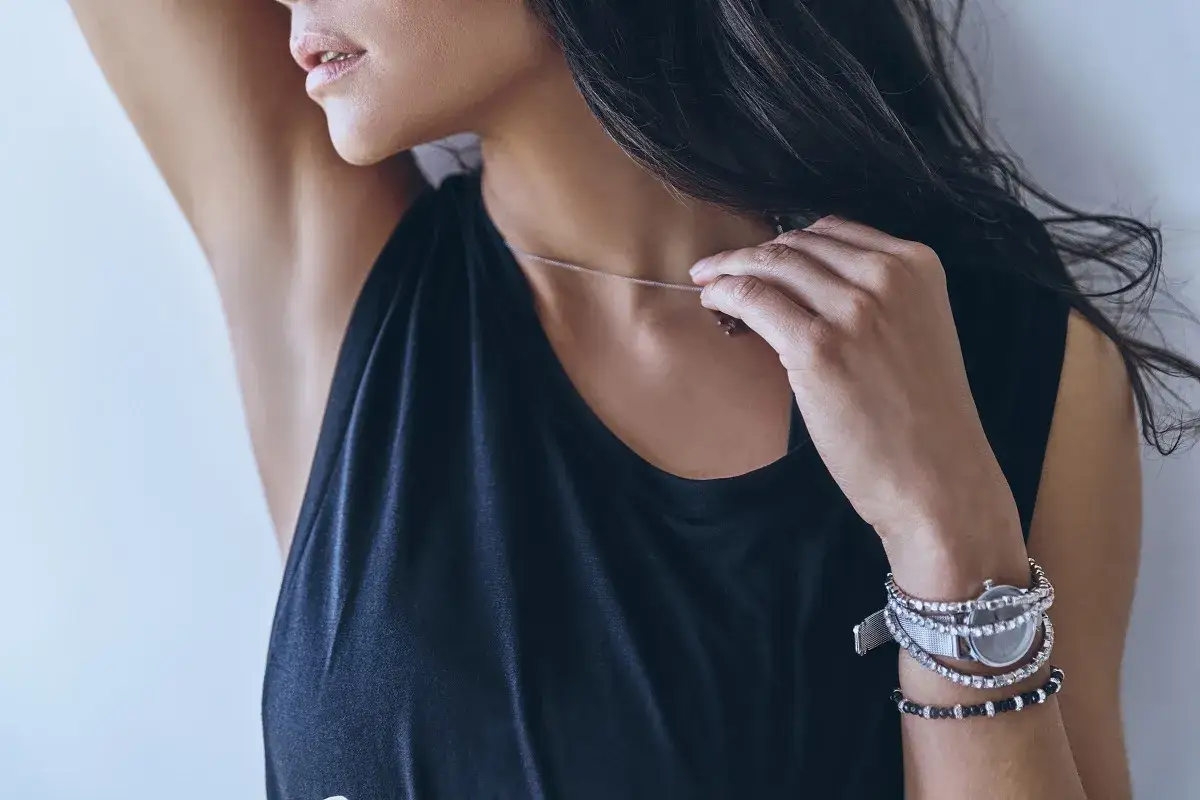 Elegancka bransoletka i zegarek jak nosić, by stworzyć stylowy look. Delikatny naszyjnik dopełnia całość.